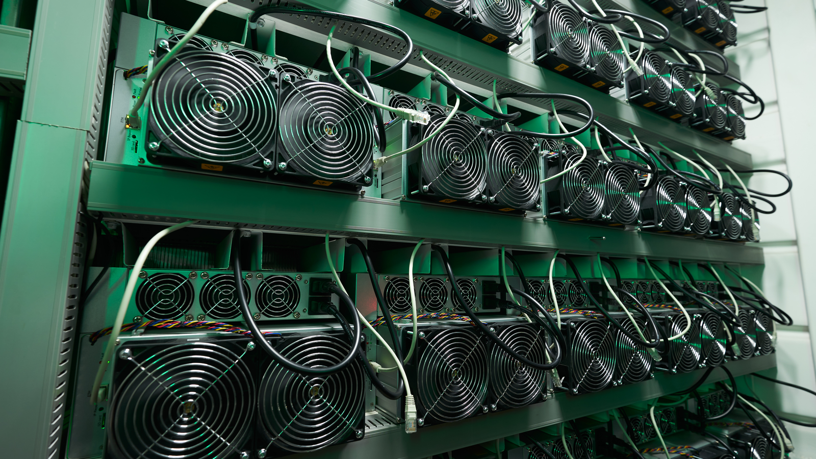 Bitcoin miners in large farm. ASIC mining equipment on stand racks mine cryptocurrency in steel container. Blockchain techology application specific integrated circuit datacenter. Server room lights. SOS Stock