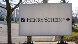 HSIC stock / Henry Schein logo on a sign outside of their building in Canada.