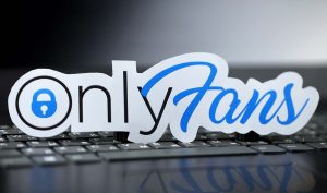 The logo for OnlyFans displayed on a laptop keyboard.