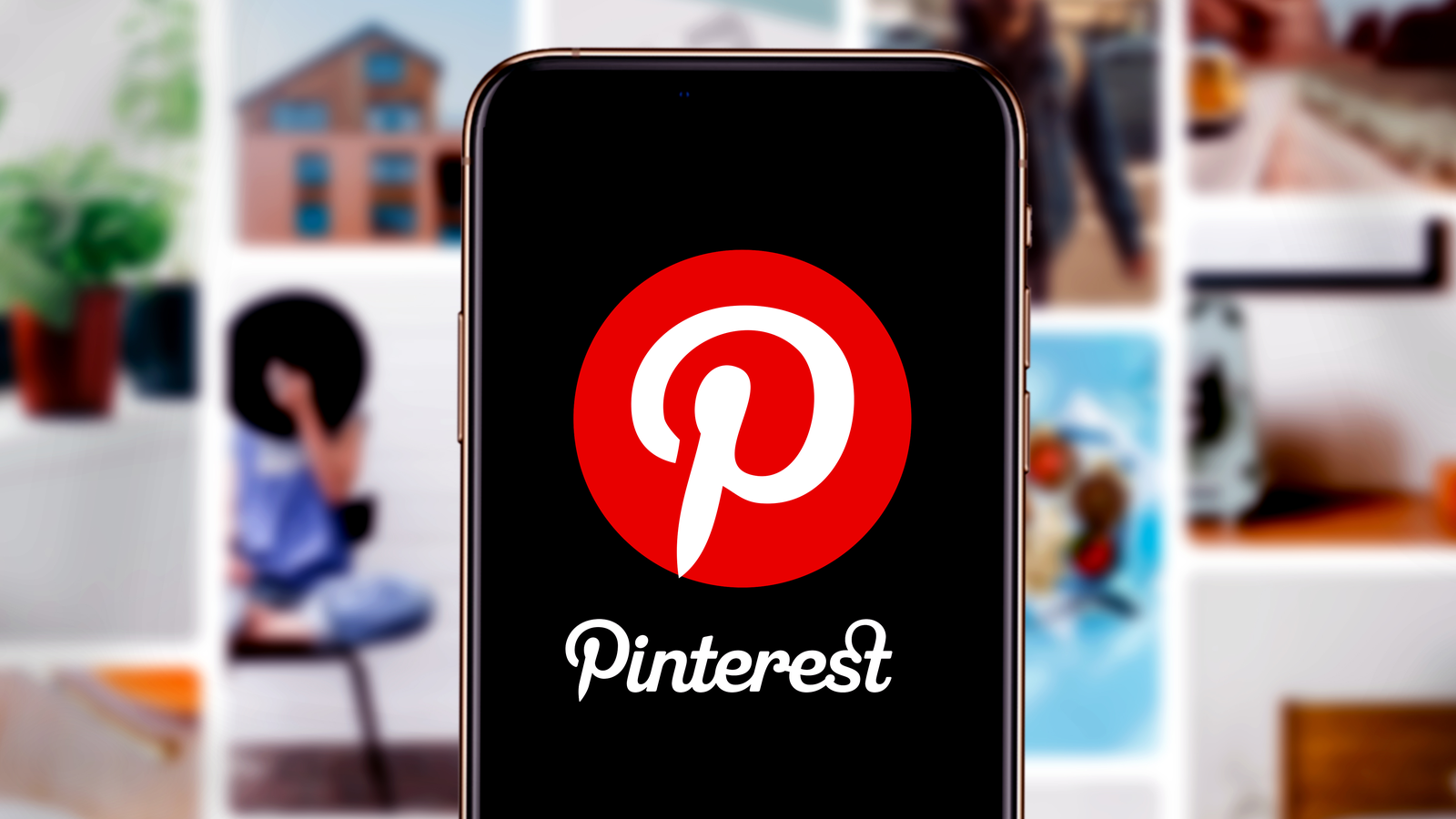 Smart phone with the Pinterest (PINS Stock) logo in front of blurred out pinterest post pictures