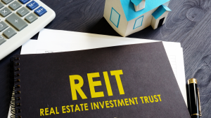 オフィスの机で不動産投資信託REITを購入するREIT。