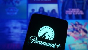 PARA stock: the Paramount plus logo on a phone in front of a screen displaying various Paramount TV shows and movies