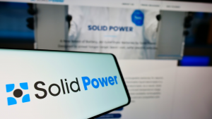 Smartphone with logo of American battery company Solid Power Inc. on screen in front of business website. Focus on center-left of phone display.