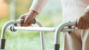 A close-up photo of a person using a walker.