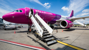Airbus A320 Wizz Air with attached passenger boarding stairs. Airport equipment.
