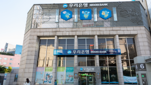 The Woori Bank logo, owned by Woori Financial Group, is seen on a branch.  The building is decorated with illustrations of bees.