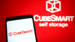 In this photo illustration CubeSmart logo of a real estate investment trust (CUBE) is seen on a mobile phone and a computer screen.