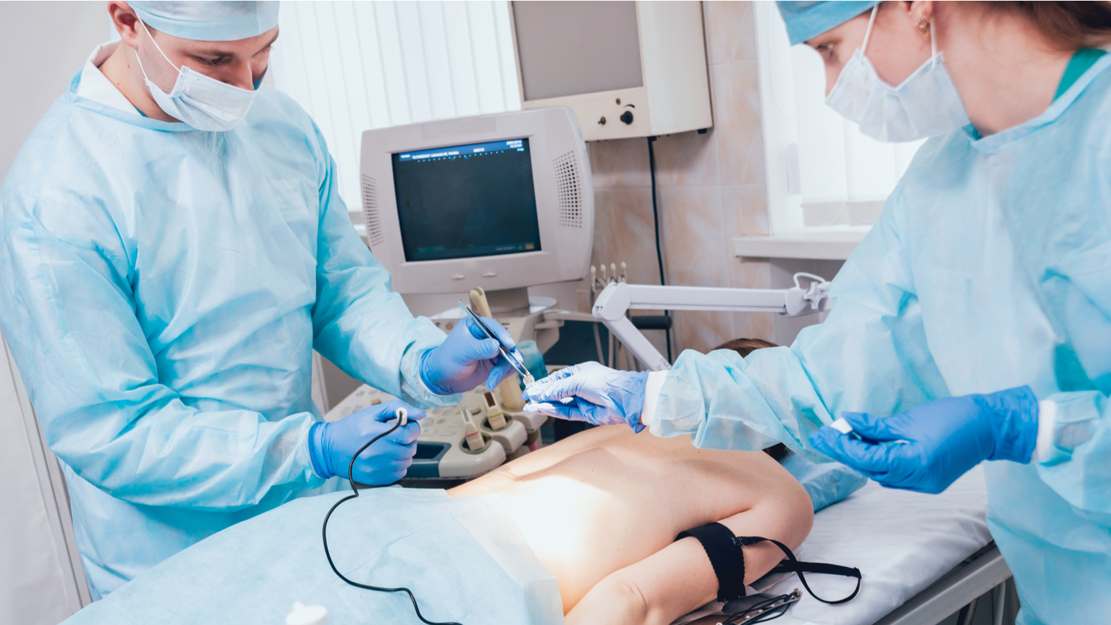 An image of two medical professionals performing a procedure on a patient