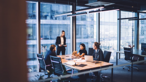 Group of colleagues discuss something in an office conference room.