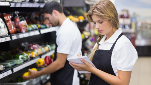 Retail workers checking produce at a grocery store representing the March Jobs Report 2022.