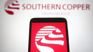 Southern Copper Corporation logo on a phone screen in front of the logo on a computer screen. SCCO stock.