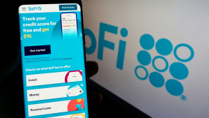 Person holding smartphone with website of US financial company Social Finance Inc (SoFi) on screen with logo focus on the center of the phone display