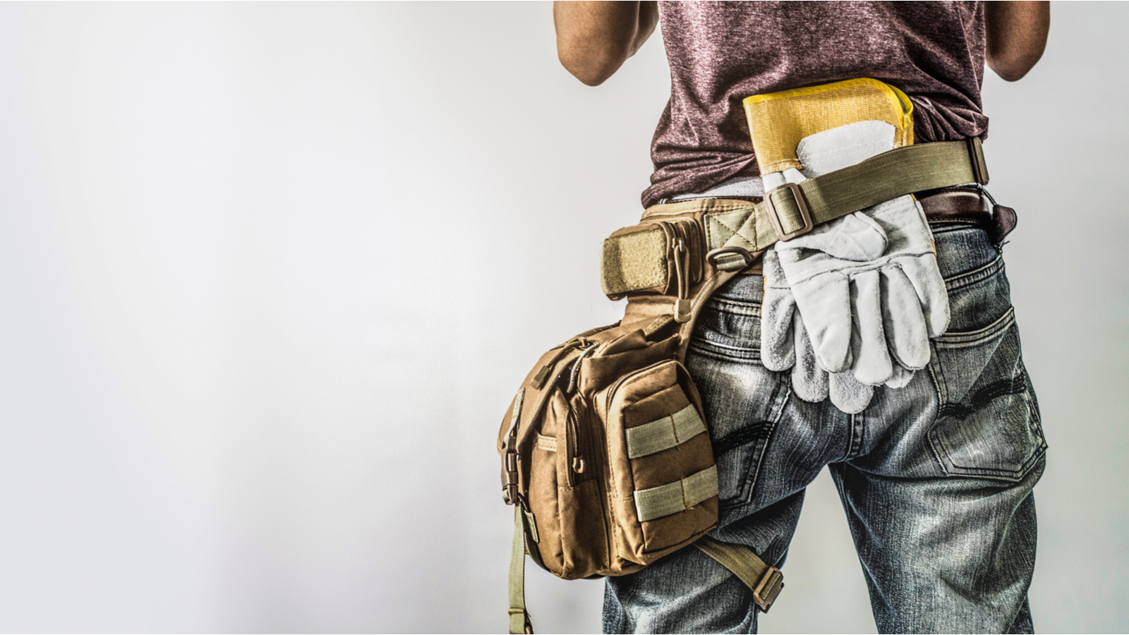 A man wearing dirty clothes with a tool belt around his waist representing tblt stock.