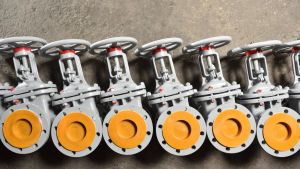 Several new gray valves, for water or gas, lie on the floor at the factory. The valves are gray for water or gas at the factory of the manufacturer