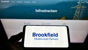 Brookfield Infrastructure logo on a phone screen in front of a blurred computer screen. BIPC stock.