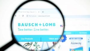 A magnifying glass zooms in on the Bausch + Lomb (BLCO) website.
