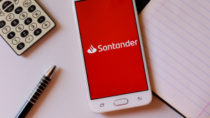 Santander bank app on smartphone screen on office desk with calculator and pen. Santander internet banking concept. BSBR stock.