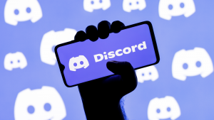 Discord logo on a phone screen in front of a blurred purple background with discord logo. Discord IPO.