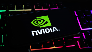 Close-up of mobile phone screen with nvidia corporation logo lettering on computer keyboard.  NVDA Stock.