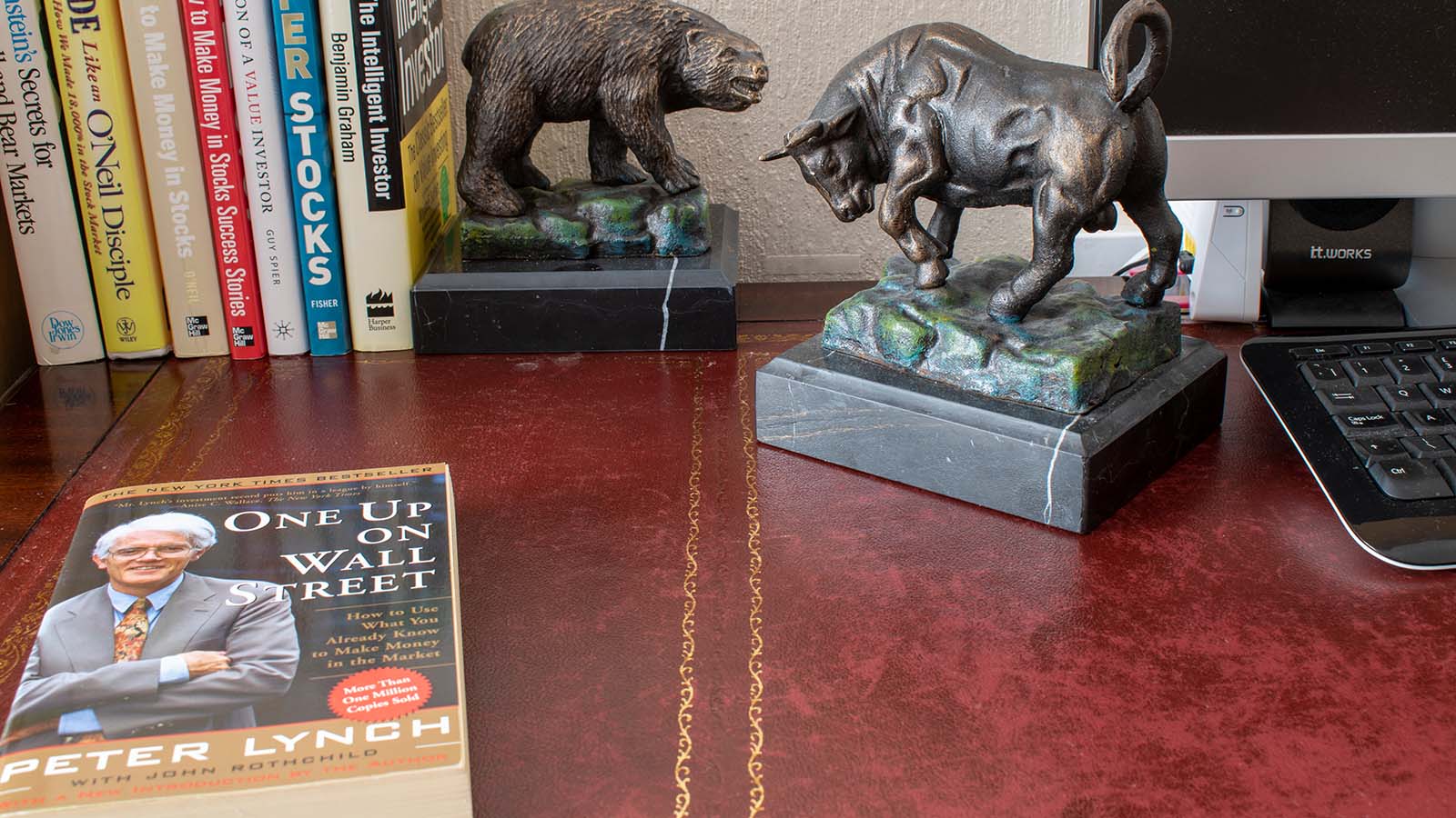 Peter Lynch's One Up on Wall Street sits on a desk next to bull and bear paperweights.
