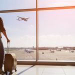 Plane travel. Man standing in airport waiting for flight. travel stocks to buy