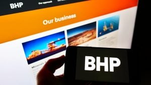 Smartphone with BHP Group logo in front of BHP website. BHP stock.