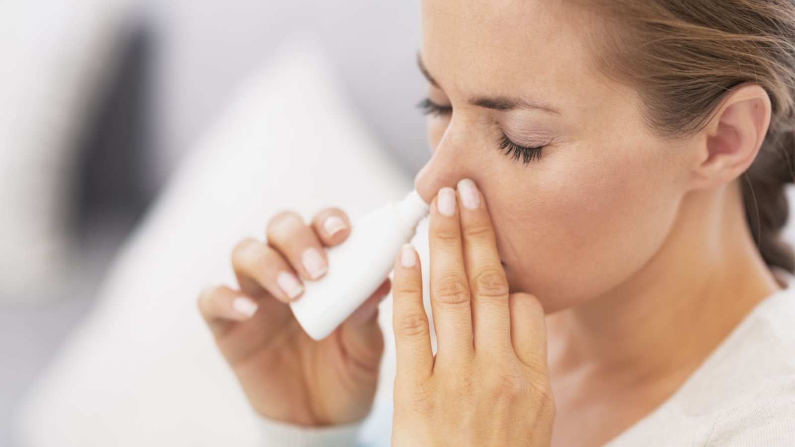 A woman using nasal spray representing EVOK stock.