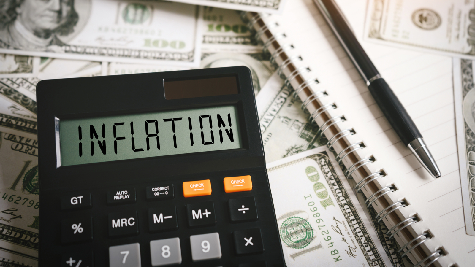 "Inflation" written on calculator with money in the background. Inflation