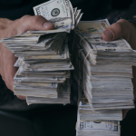 Man holding stacks of money. Millionaire.