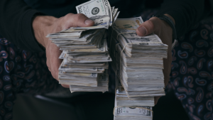 Man holding stacks of money. millionaire stocks.