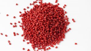 A photo of a pile of red polypropylene plastic pellets.
