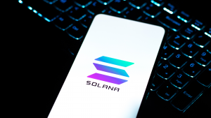Solana logo on phone screen stock image. SOL-USD, Solana price predictions
