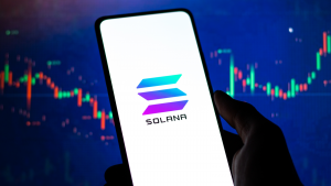 Solana logo on phone screen stock photo. Solana price predictions.