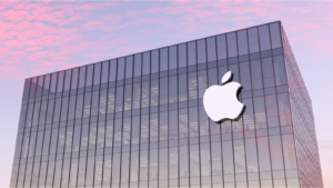 An image of a building with the Apple logo on it, a pink sunset in the background