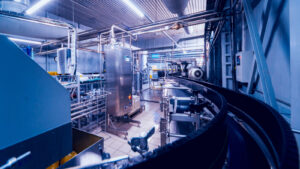 A photograph of the inside of a factory showing machinery and conveyer belts.