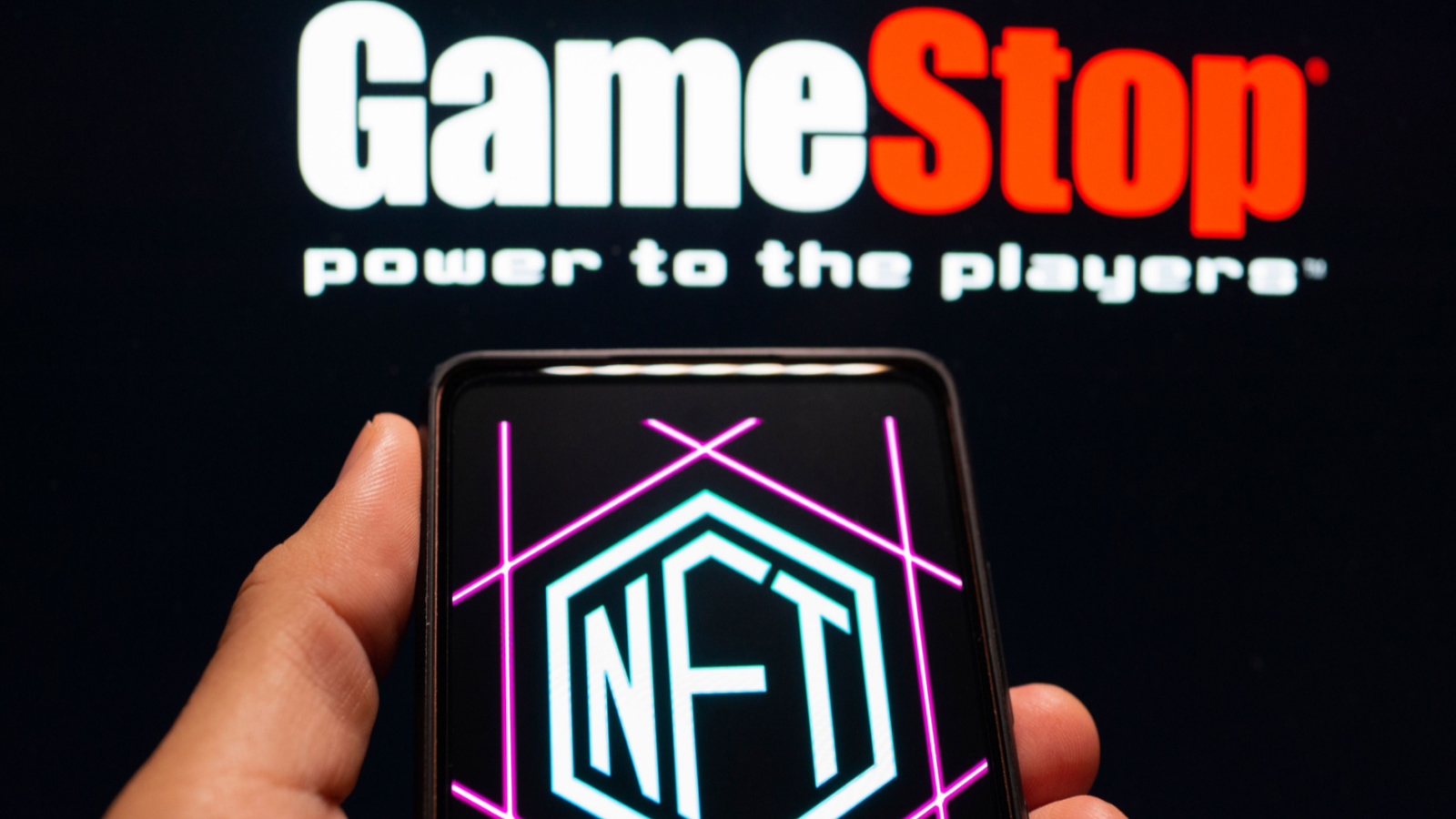 The GameStop (GME) logo above the NFT logo on a smartphone.