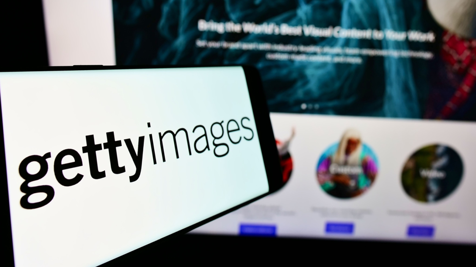 GettyImages (GETY Stock) logo on a smartphone in front of a computer.