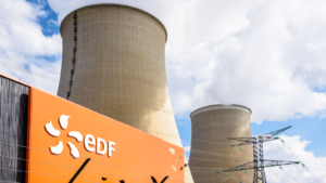 ECIFY stock: Low angle view of the EDF (Electricité de France) sign at the entrance of the nuclear power plant of Nogent-sur-Seine and the two cooling towers.