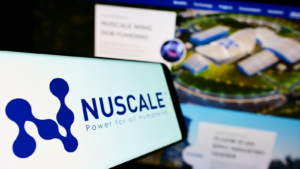 SMR stock: Smartphone with logo of American nuclear power company NuScale Power LLC on screen in front of business website.