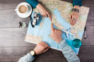 Top view of a couple pointing on a map as they plan for a vacation trip
