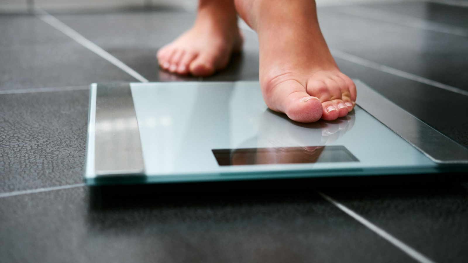 A person stepping on a scale representing BNSO Stock.