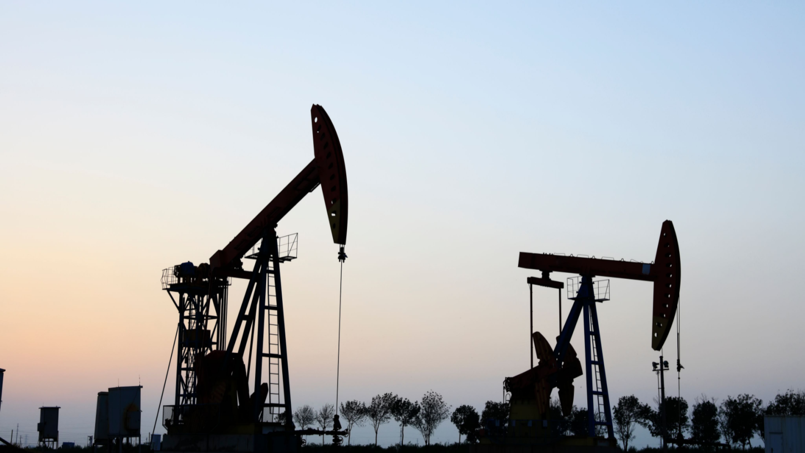 Den Stock. In the field, the oil pump in the evening, the evening silhouette of the pumping unit, the silhouette of the oil pump