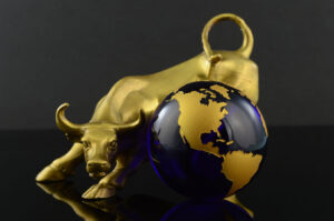 A figure of a golden bull and globe to represent an aggressive World market trends; bull market, bullish