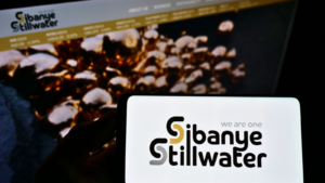 Person holding smartphone with logo of South African mining company Sibanye Stillwater Limited on screen in front of website. Focus on phone display. Unmodified photo.