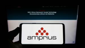 Person holding mobile phone with logo of American company Amprius Technologies (AMPX) Inc. on screen in front of web page. Focus on phone display. Unmodified photo.