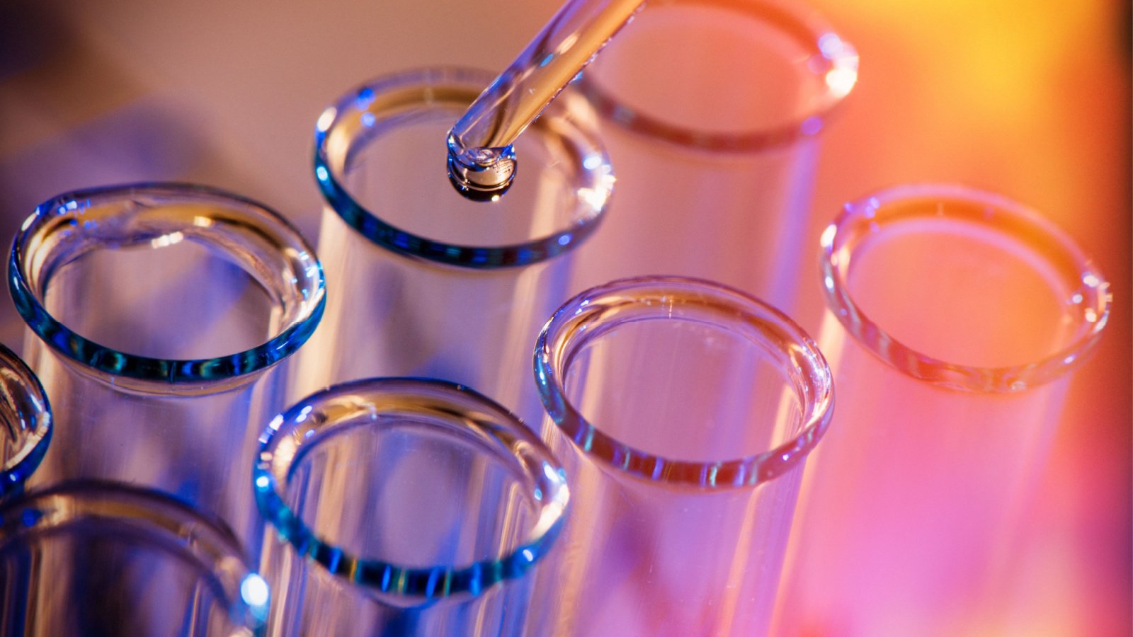 Phot of test tubes and droplet with purple and reddish-orange sunset visual effect