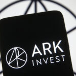 Logo for Ark Invest displayed on phone with logo in background as well, symbolizing Cathie Wood stocks