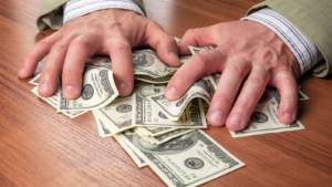 Man's hand holding a bundle of cash