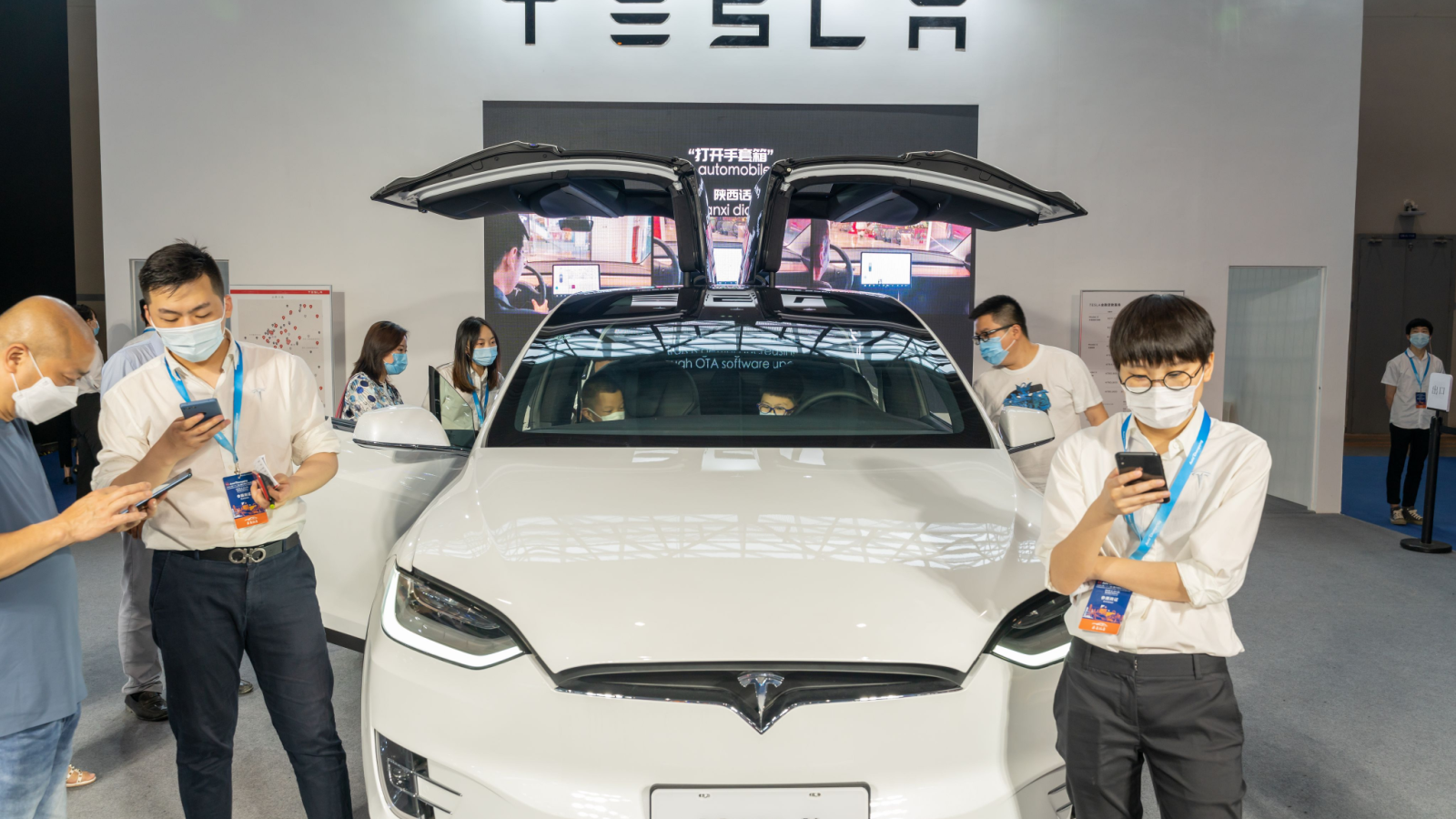 Tesla (TSLA stock) model X displayed in China auto expo during covid19 pandemic. Staff wearing face mask.