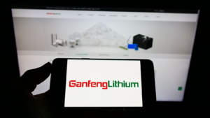 Person holding cell phone with logo of Chinese company Jiangxi Ganfeng Lithium Co. Ltd.  (GNENF) on the screen in front of the web page.  Focus on the phone screen.  Unedited photo.